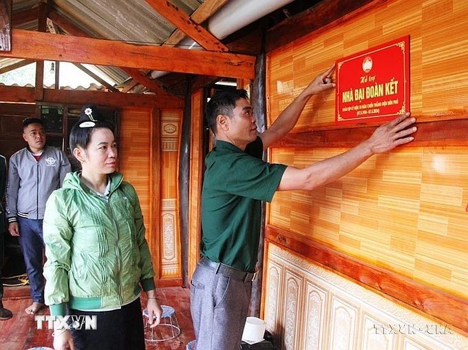 奠边省奠边东市镇第一街坊组卢文贤一家高兴地入住获捐建的大团结屋。 (图:《越通社》) NHA-DAI-DOAN-KET.jpg