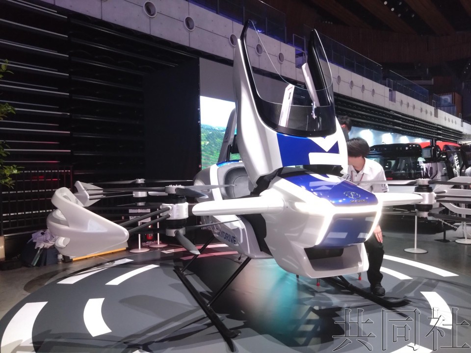 图为 5月21日在东京都江东区展示可试乘的SkyDrive公司的“空中飞行汽车”模型机。(图:共同社)
