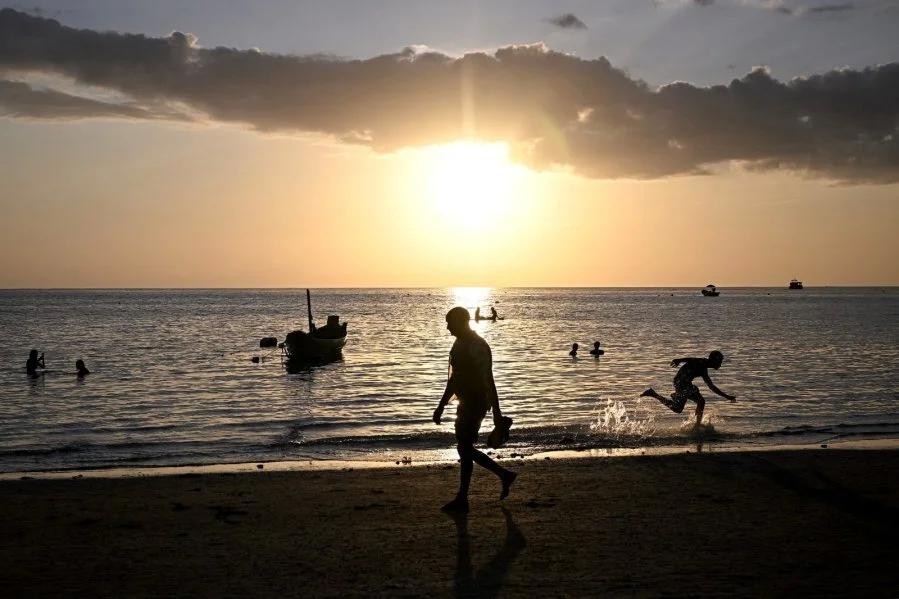 在泰国湾涛岛的塞利海滩,人们在夕阳下漫步。(图:AFP)