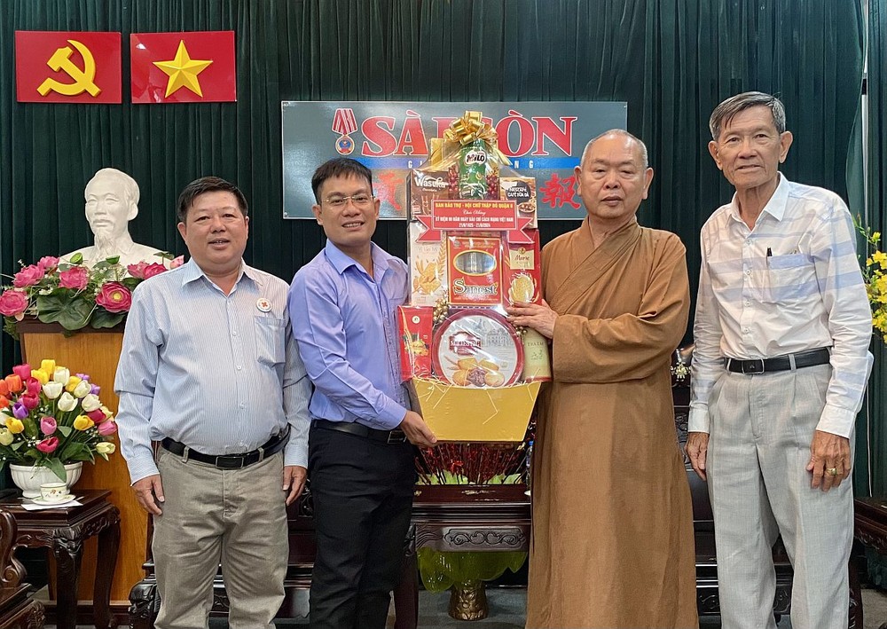 本报编委文忠孝(左二)接受第八郡红十字会和辅助会赠送的祝贺礼物。