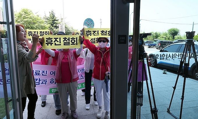 6月13日,在首尔龙山区的大韩医师协会大楼前,多个患者团体举行集会,敦促医疗界撤回集体停诊计划。(图:韩联社)