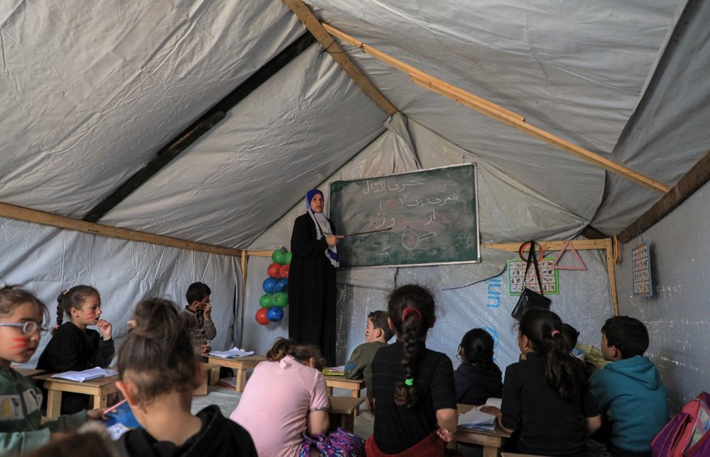 一名教师在临时搭建的教室内为学生授课。（图：互联网）