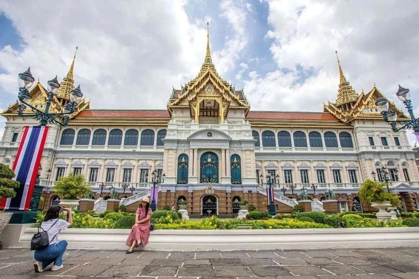 游客在泰国曼谷大皇宫前拍纪念照。(图:越通社)