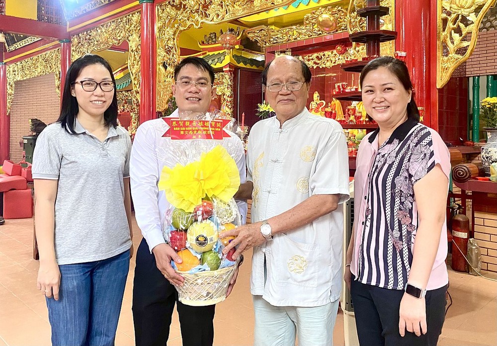 文忠孝编委(左二)向温陵会馆理事长洪世真(右二)赠送果篮敬奉观音娘娘。