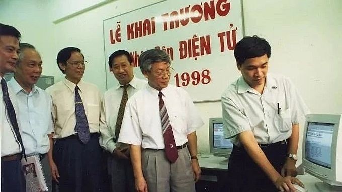 在1998年6月21日,时任党中央政治局委员、负责思想-文化与教科工作的阮富仲同志(右二)在《人民报》电子版开刊当天检查新闻报导资料。