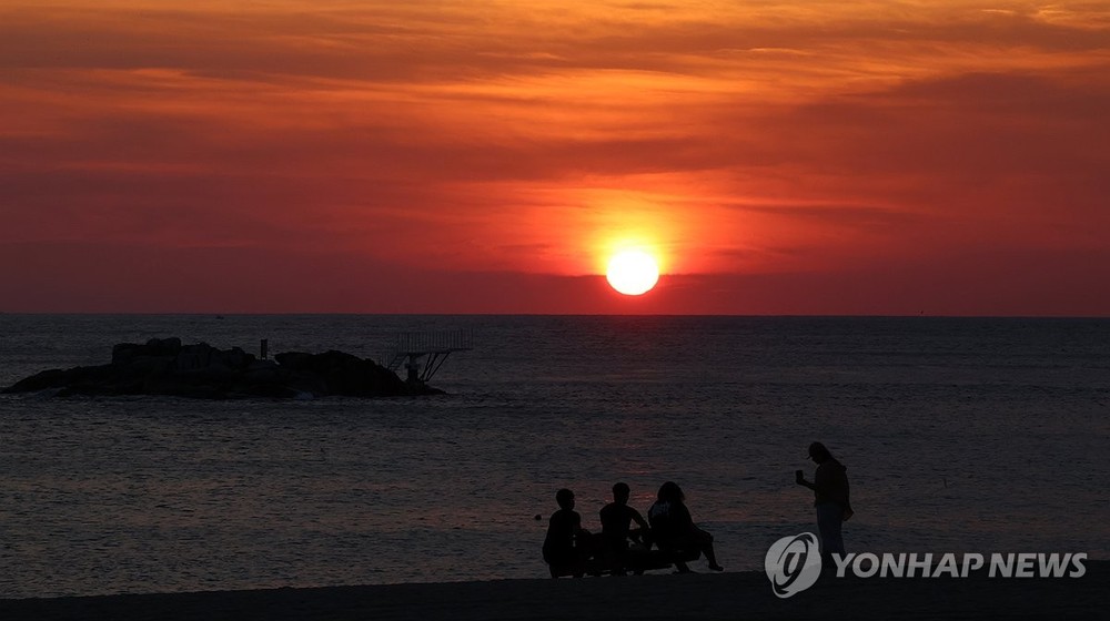 图为 8月23日，在江原道江陵市镜浦海水浴场，红日冉冉升起。（图：韩联社）