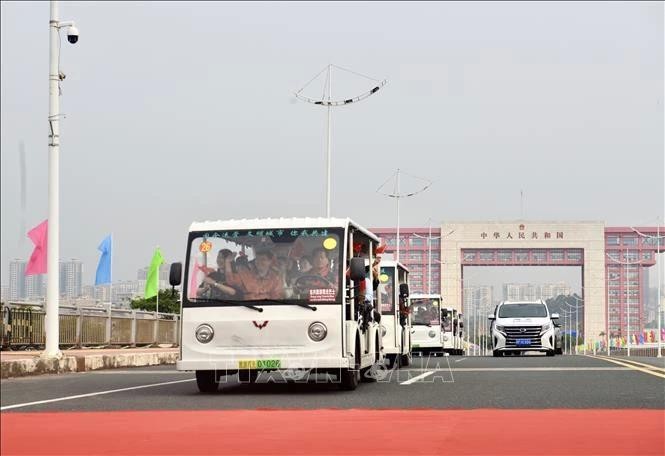 一团旅游车队从中方边境口岸开往我国广宁省芒街国际口岸。(图:越通社)