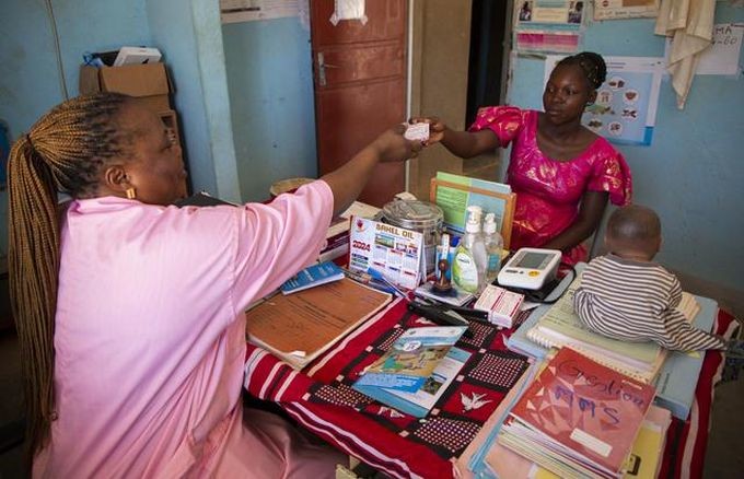 布基纳法索 Ziniaré 卫生中心的卫生工作者向孕妇赠送一盒 MMS 药片。(图:UNICEF)