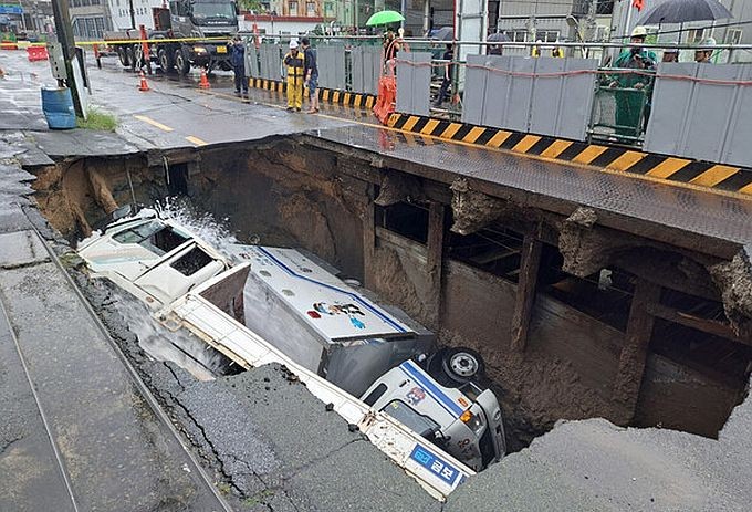 釜山沙上区某道路发生大型地陷，2辆卡车坠入坑中。（图：互联网）