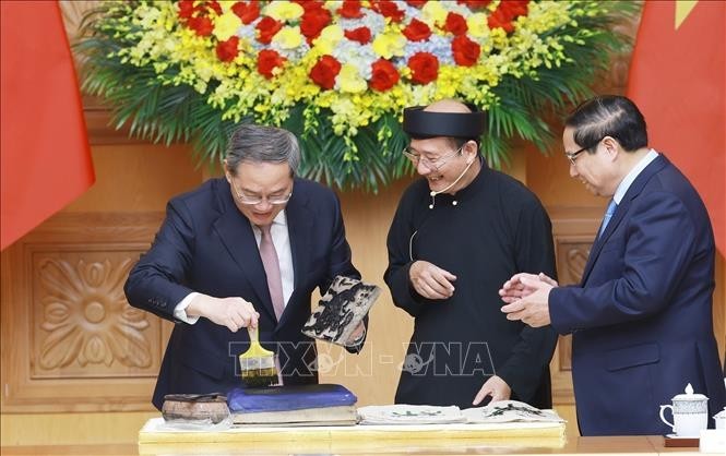 中国国务院总理李强体验东湖画印制。（图：越通社）