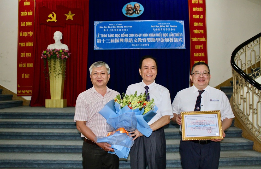 华文《西贡解放日报》编委黎曰孟雄向越南台商奖学基金会董事长苏建源、执行长洪志华颁发感谢状和赠送鲜花。 HB2.jpg