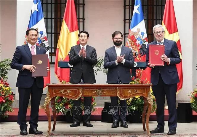 国家主席梁强与智利总统博里奇见证两国外交部部长签署越南-智利联合声明。(图:越通社)