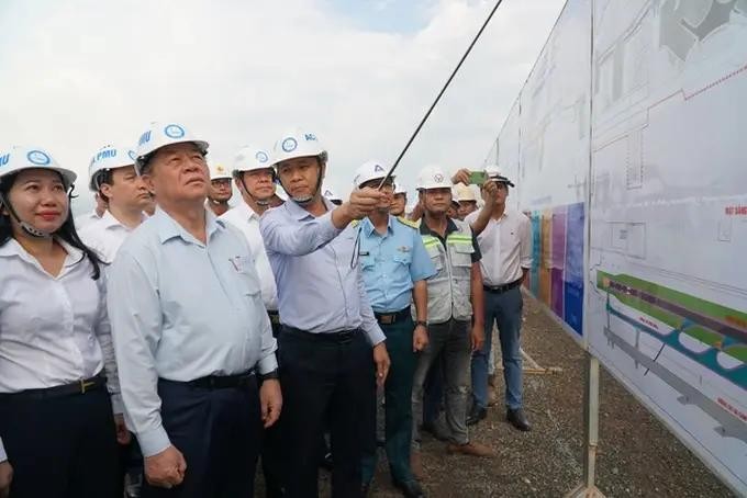中央宣教部长阮仲义与工作团正在听取讲解员介绍隆城机场工程项目。(图:黎霖)