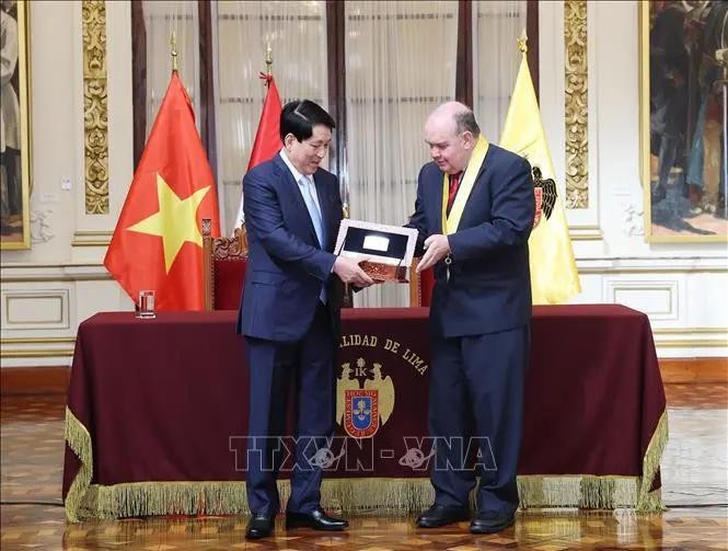 洛佩斯·阿里亚加市长向梁强主席授予首都利马象征的钥匙。(图:越通社)