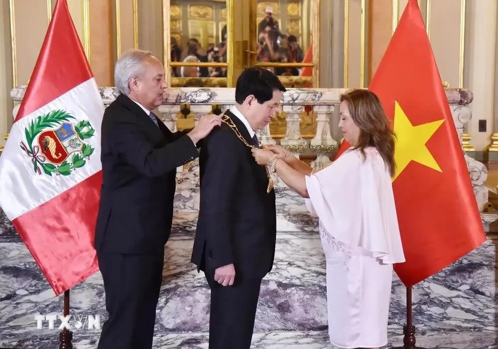 秘鲁总统迪娜·博卢阿特向梁强主席授予秘鲁“大十字太阳”勋章。(图:越通社) 秘鲁总统迪娜·博卢阿特向梁强主席授予秘鲁“大十字太阳”勋章。(图:越通社)