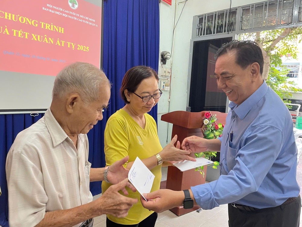 第十一郡高龄人会主席朱杞文向老人赠送礼物。