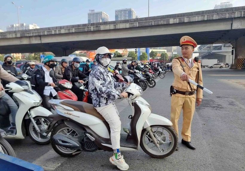 一名摩托车手违反交通信号灯,被执勤交警拦停。(图:越通社)