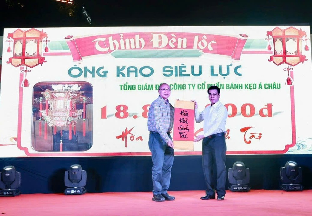 市人委会副主席阮文勇祝贺亚洲饼家(ABC Bakery)总经理高肇力投得圣灯。
