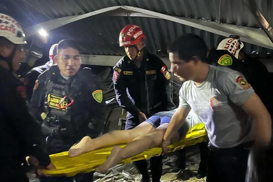救援人员用担架将一名受害者抬离现场。(图:AFP)