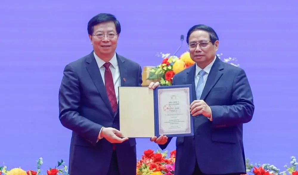 清华大学党委书记邱勇教授向越南政府总理范明政授予清华大学“名誉教授”称号。（图：越通社）