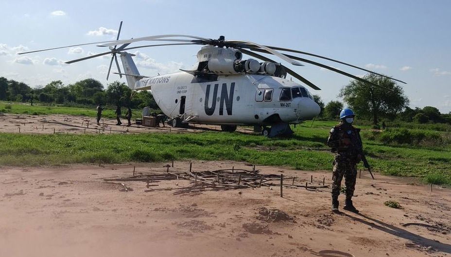 一名南苏丹特派团维和人员守卫着一架紧急降落的直升机。（图：南苏丹特派团）