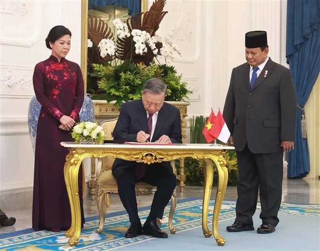 苏林总书记在嘉宾簿上签名。（图：越通社）