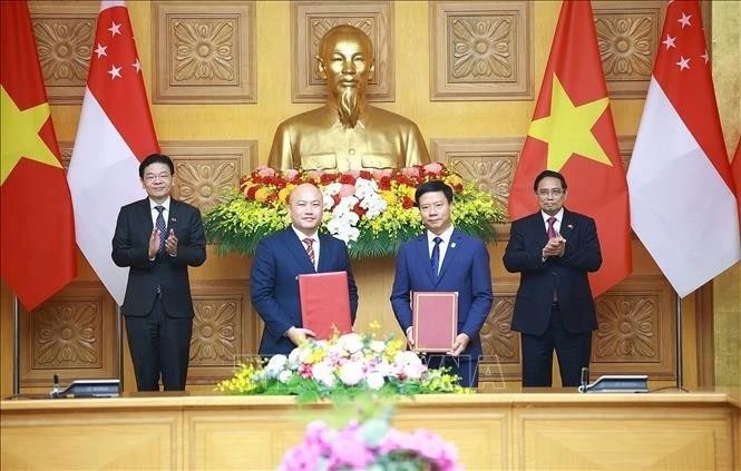 政府总理范明政(右一)与新加坡总理黄循财(左一)共同见证越南友好协会与新加坡国际基金会合作备忘录的签署。(图:越通社) KY-KET.jpg