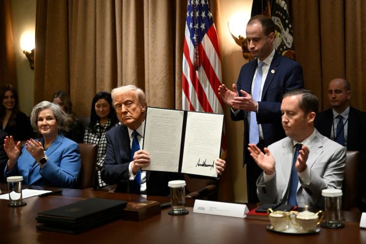 3月25日，特朗普展示他签署的行政命令。（图：AP）