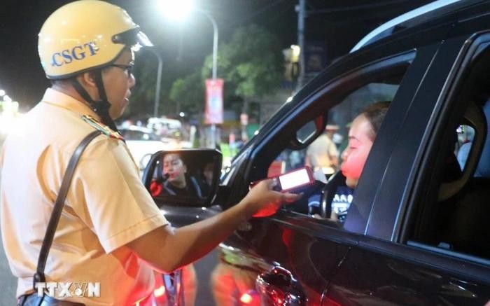 执勤交警正在对一名司机进行呼气式酒精测试。（图：越通社）