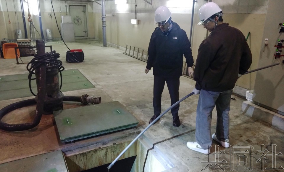 4月4日，东京大学特聘教授北岛正章（左）等人正在机场采集排水样本。（图：共同社）