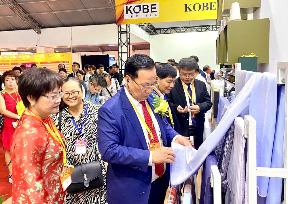 越南纺织协会主席武德江与各代表参观展品。