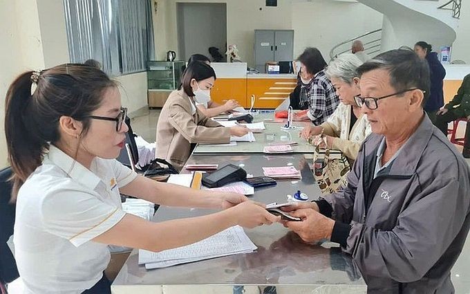 退休干部正在办理手续领取退休金。（示意图：互联网）