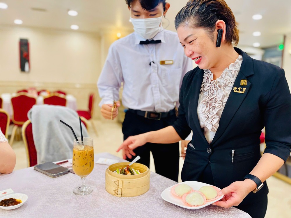 爱华2酒楼员工向食客介绍新推出的点心。