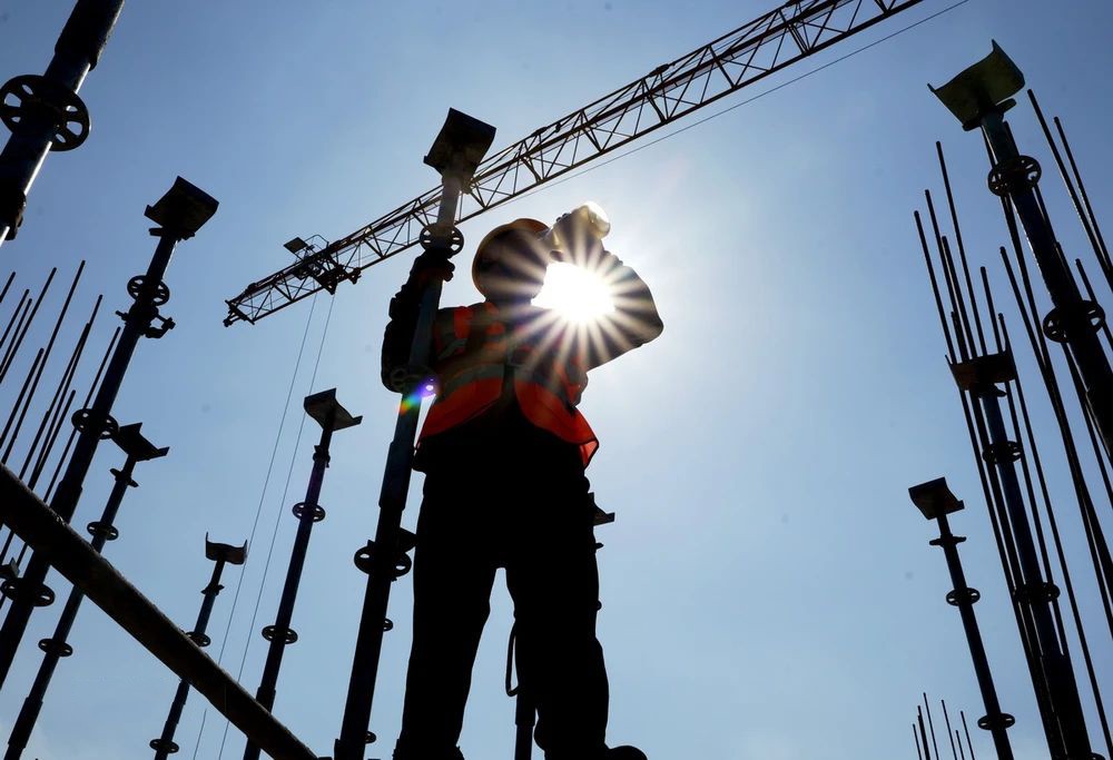 工人们在烈日下工作。（图：越通社）