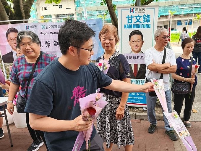 5月10日,香港屯门龙门路富健花园街头,有区议员设摊位向街坊派发花束,庆祝母亲节。 (图:香港中通社)