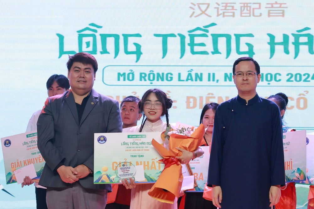 中国驻胡志明市总领事馆副总领事徐州(右)与文献大学外语系中文专业主任阮进长安老师向赢得汉语配音冠军颁奖。