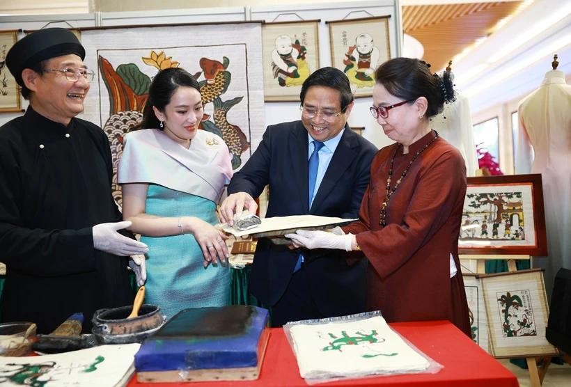 越南政府总理范明政与泰国总理佩通坦参观了解越南东胡画制作工艺。(图:越通社)