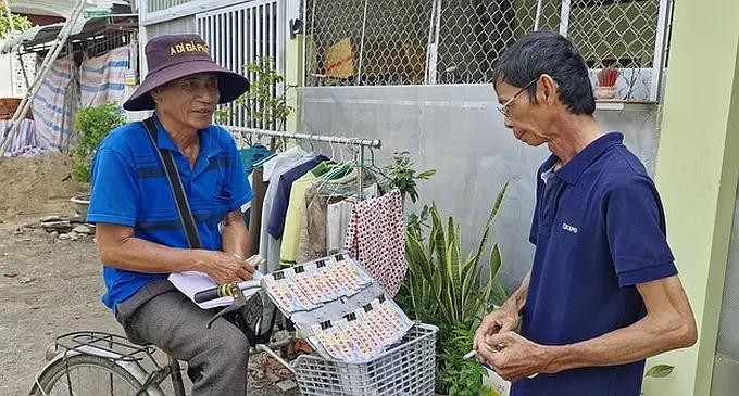 一名大叔骑着自行车靠兜售彩票谋生。(图:黎民)