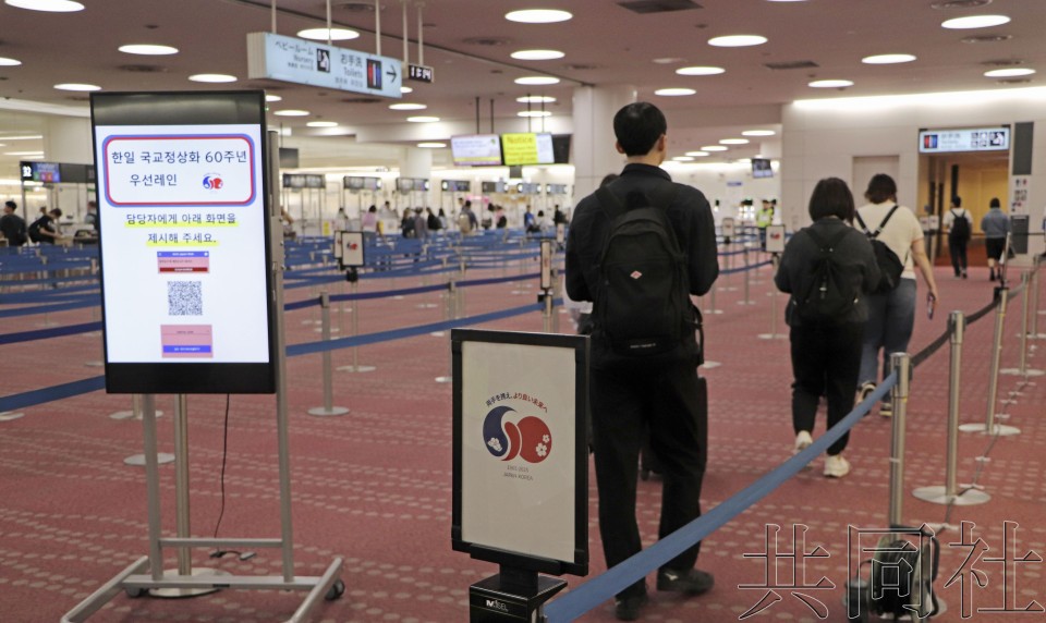 图为6月1日上午,在东京羽田机场第3航站楼使用韩国人专用入境审查通道的旅客。(图:共同社)