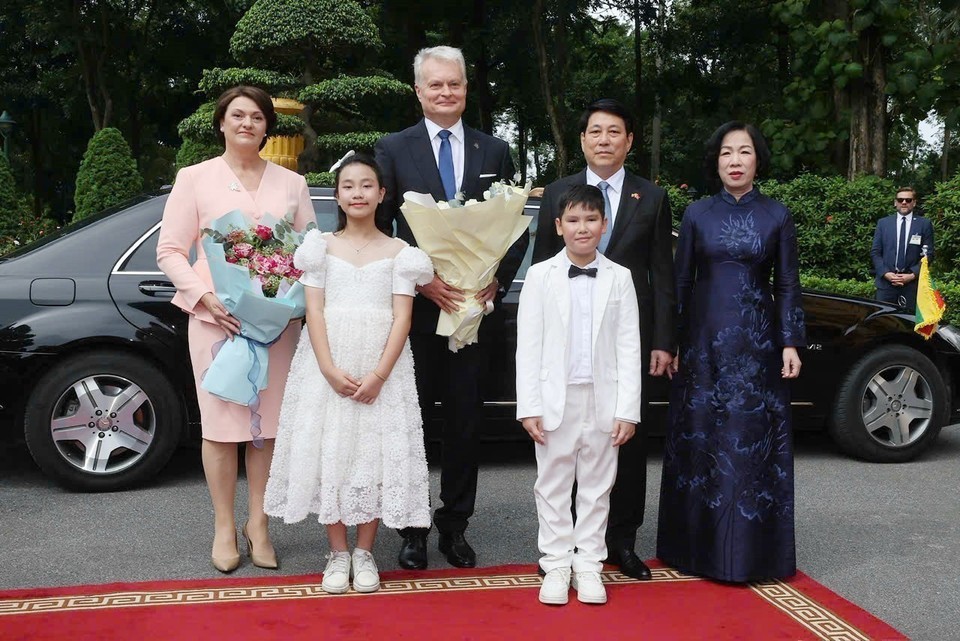 国家主席梁强和夫人同立陶宛共和国总统吉塔纳斯·瑙塞达及夫人一道，与首都少年儿童在欢迎仪式上合影留念。（图：越通社）