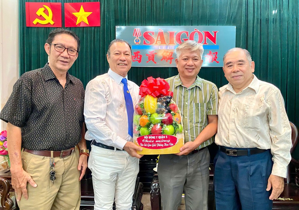 第五郡东医会向本报编委黎曰孟雄（左三）赠送礼物祝贺。