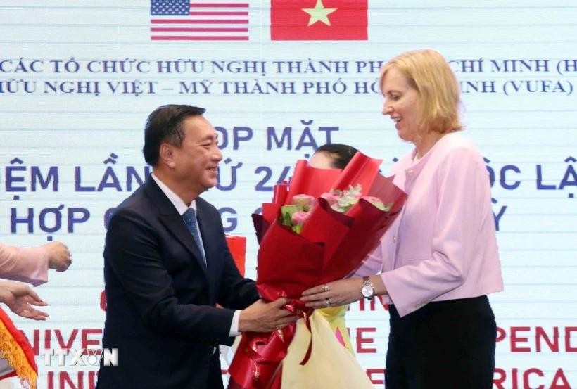市越美友好协会主席范成坚向美国驻本市总领事苏珊·伯恩斯赠送鲜花祝贺。（图：越通社）