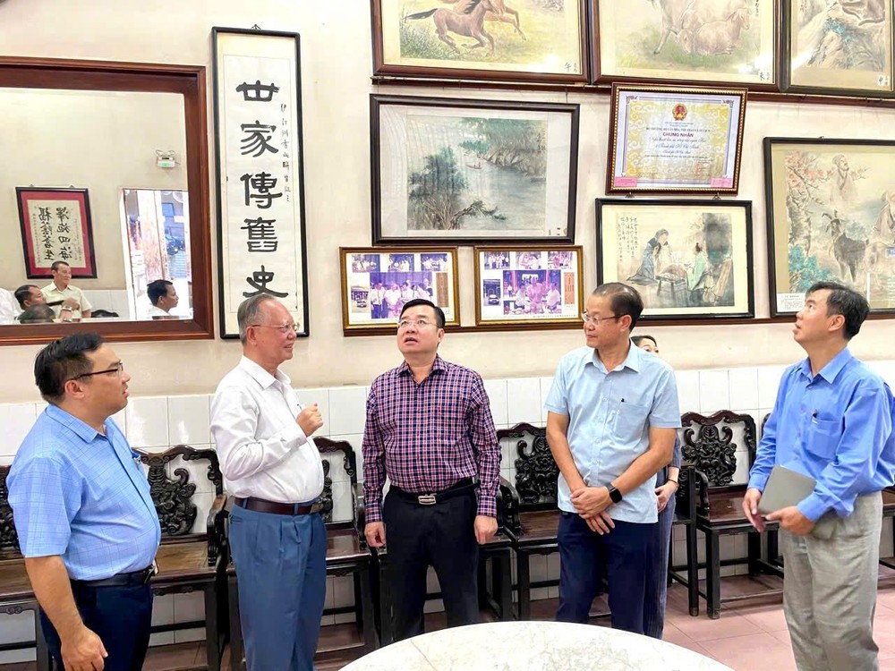 卢耀南理事长(左二)向民族与宗教厅代表团介绍穗城会馆陈列珍贵的文物。 TT3.jpg