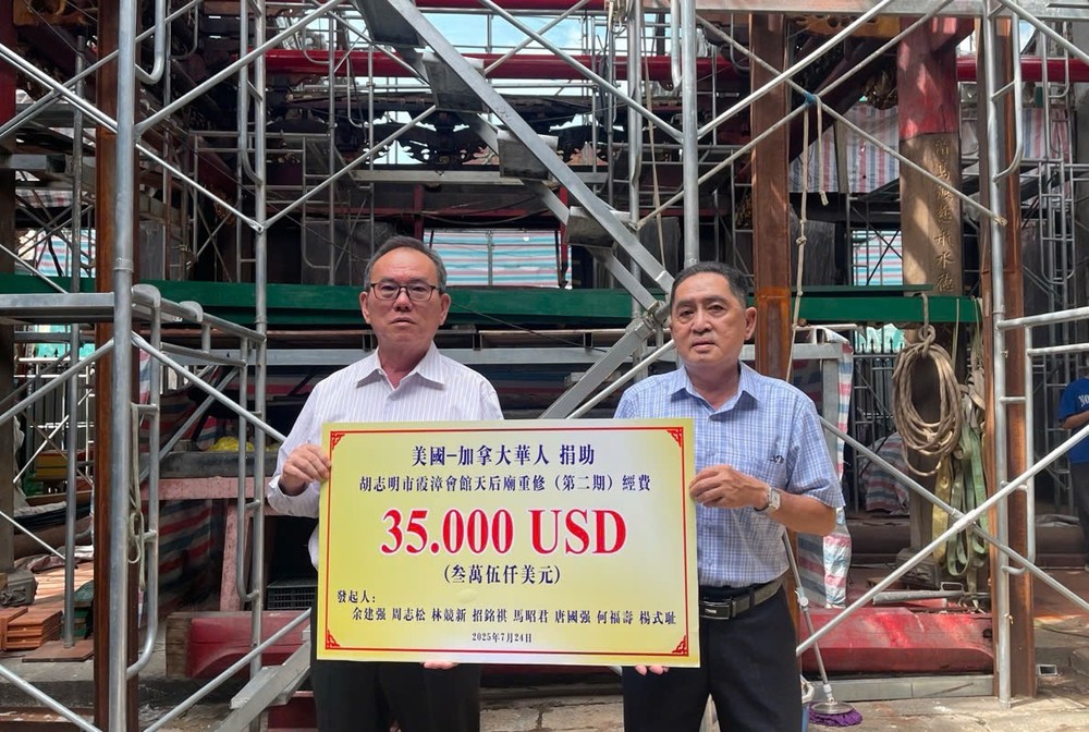 余建强(左)代表美加华人向霞漳会馆理事长沈金麟(右)移交修葺善款。