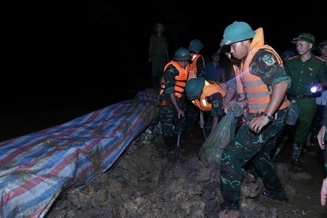 抢险力量正在加固堤防、防止洪水漫溢，确保右桥堤段安全。 （图：越通社）