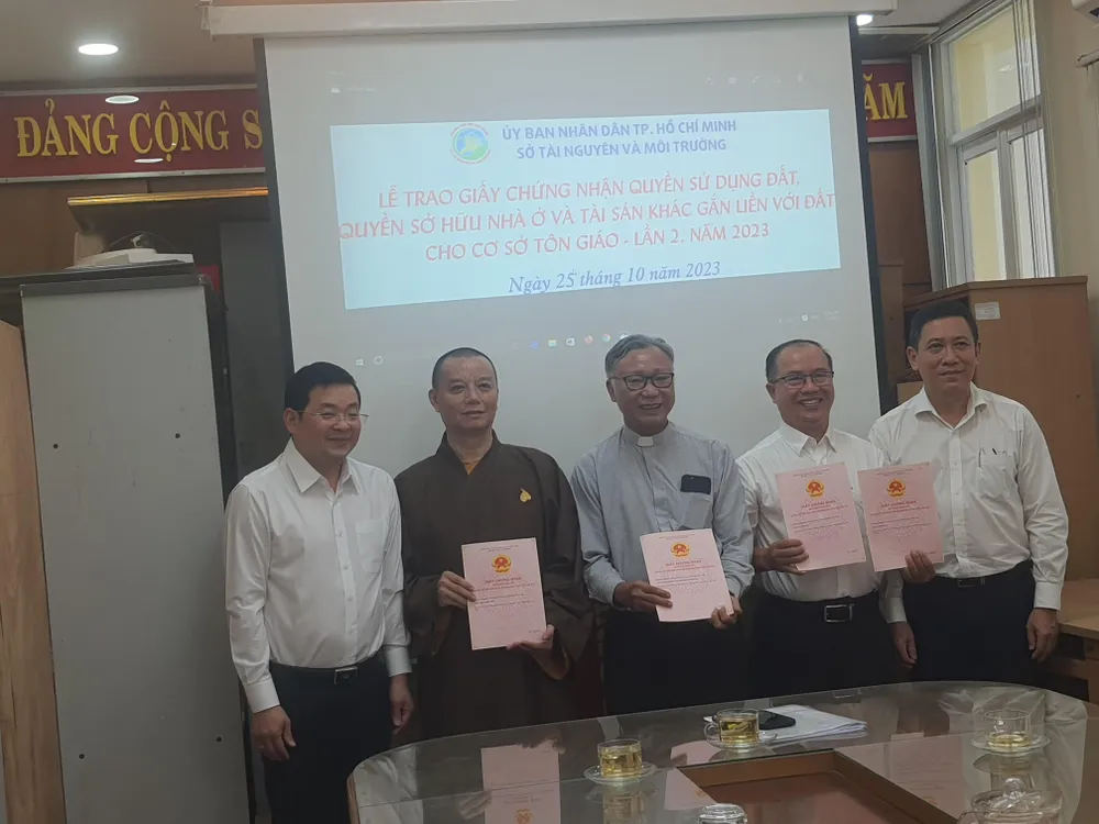 Ông Nguyễn Toàn Thắng (bìa trái) và ông Trần Xuân Điền (bìa phải) trao GCN cho các cơ sở tôn giáo.