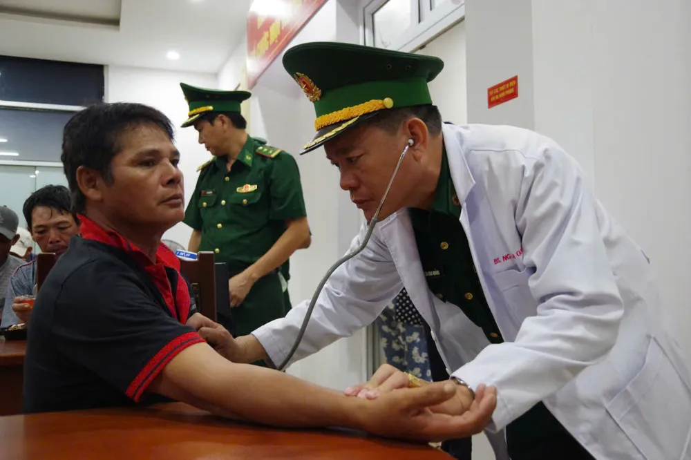 Medisch personeel van de grenswacht van de stad HCM controleert de gezondheid van de zojuist geredde vissers. thuyền viên 2.jpg