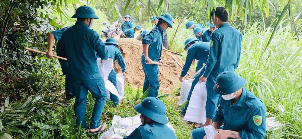 Lực lượng dân quân dồn bao cát kè đê Tiên Đào, xã Bình Sơn bongson.jpg