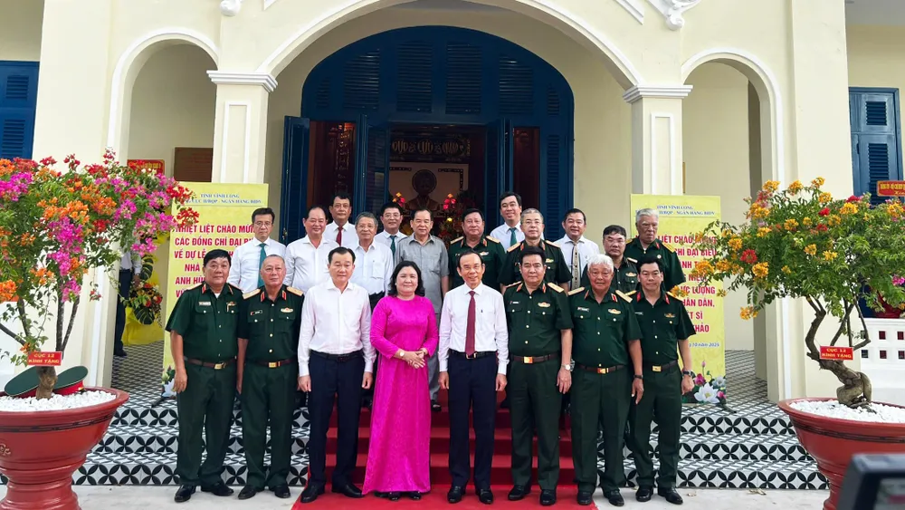 Các đại biểu chụp ảnh lưu niệm trước Nhà tưởng niệm