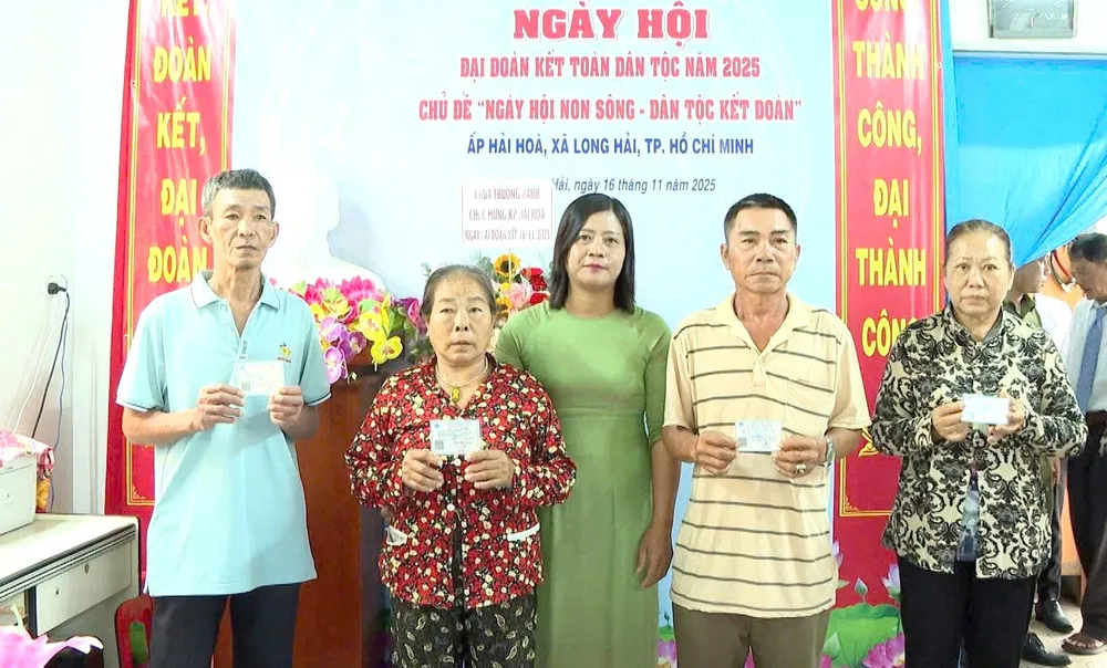 Bà Nguyễn Thị Ngọc Liên, Phó Chủ tịch Ủy ban MTTQ Việt Nam xã, Chủ tịch Hội LHPN xã Long Hải trao thẻ BHYT cho hộ khó khăn tại Ngày hội Đại đoàn kết toàn dân tộc năm 2025 ở ấp Hải Hòa